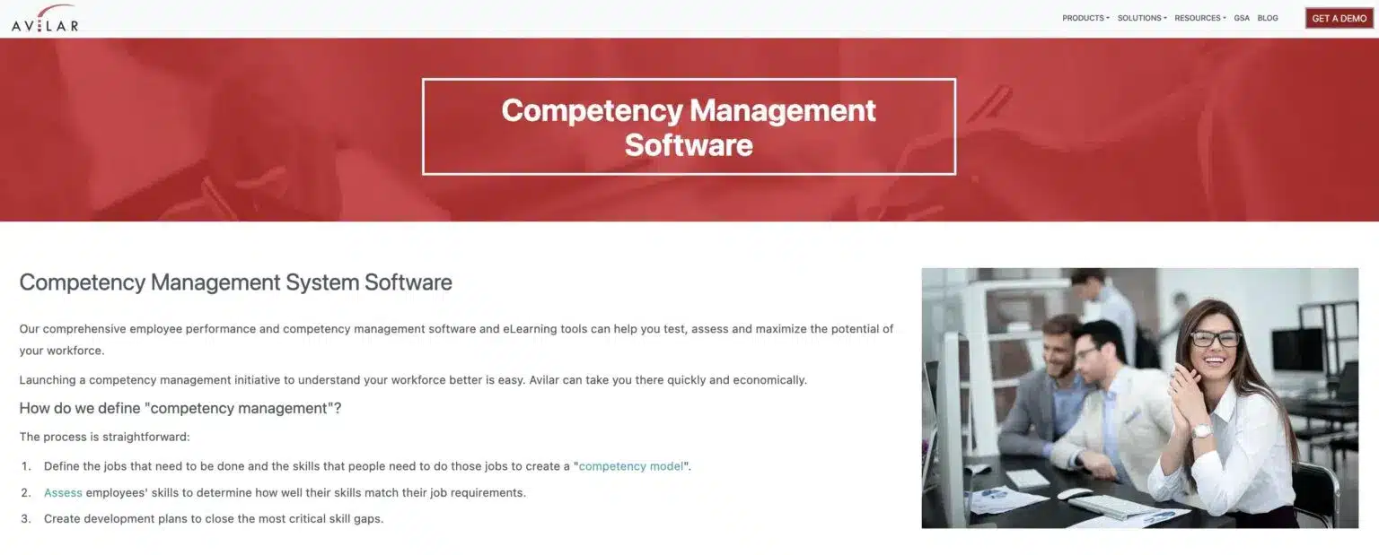 Avilar Competency Management Software website with a red banner headline that reads "Competency Management Software" and a section below titled "Competency Management System Software" describing its features. An image on the right shows three smiling professionals working together at a desk.